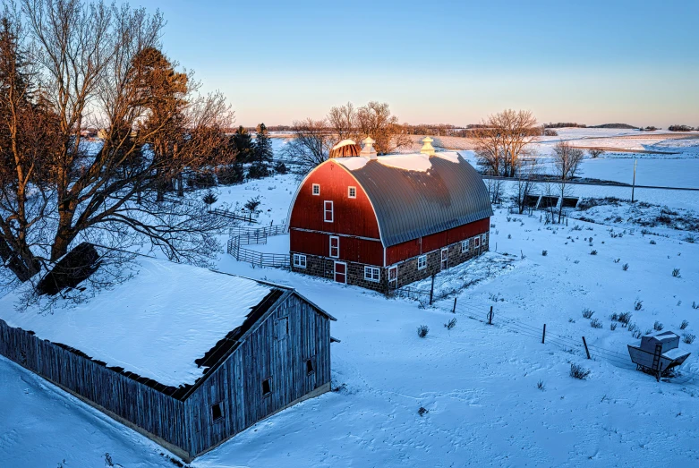 a big red barn next to a small building