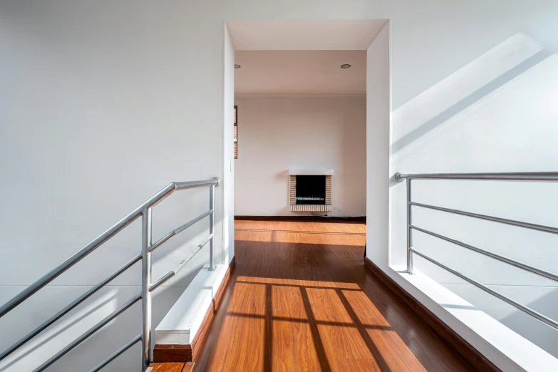 the interior of a modern home with wooden floors and railing