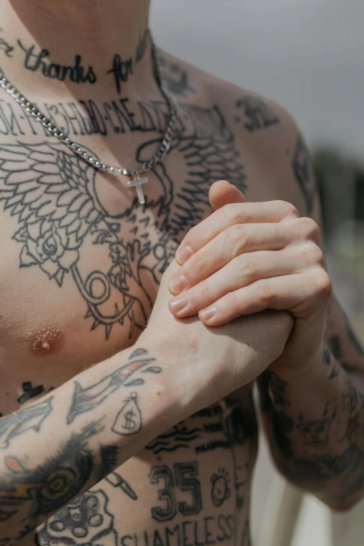 a man with tattoos holding his arms folded