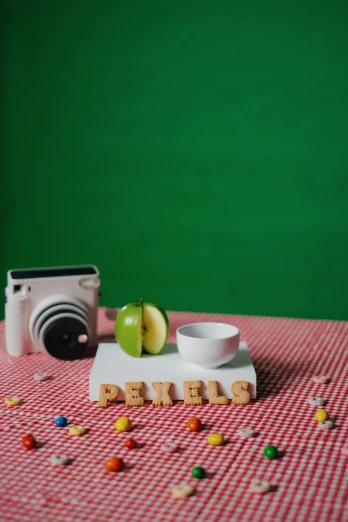 a camera, a bowl, and candy on a table