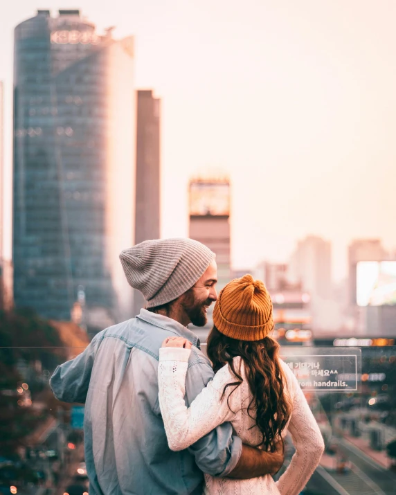 a man and woman with the city behind them