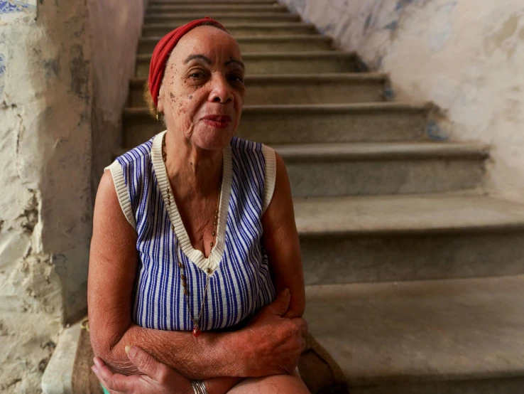 a older woman is sitting on the stairs