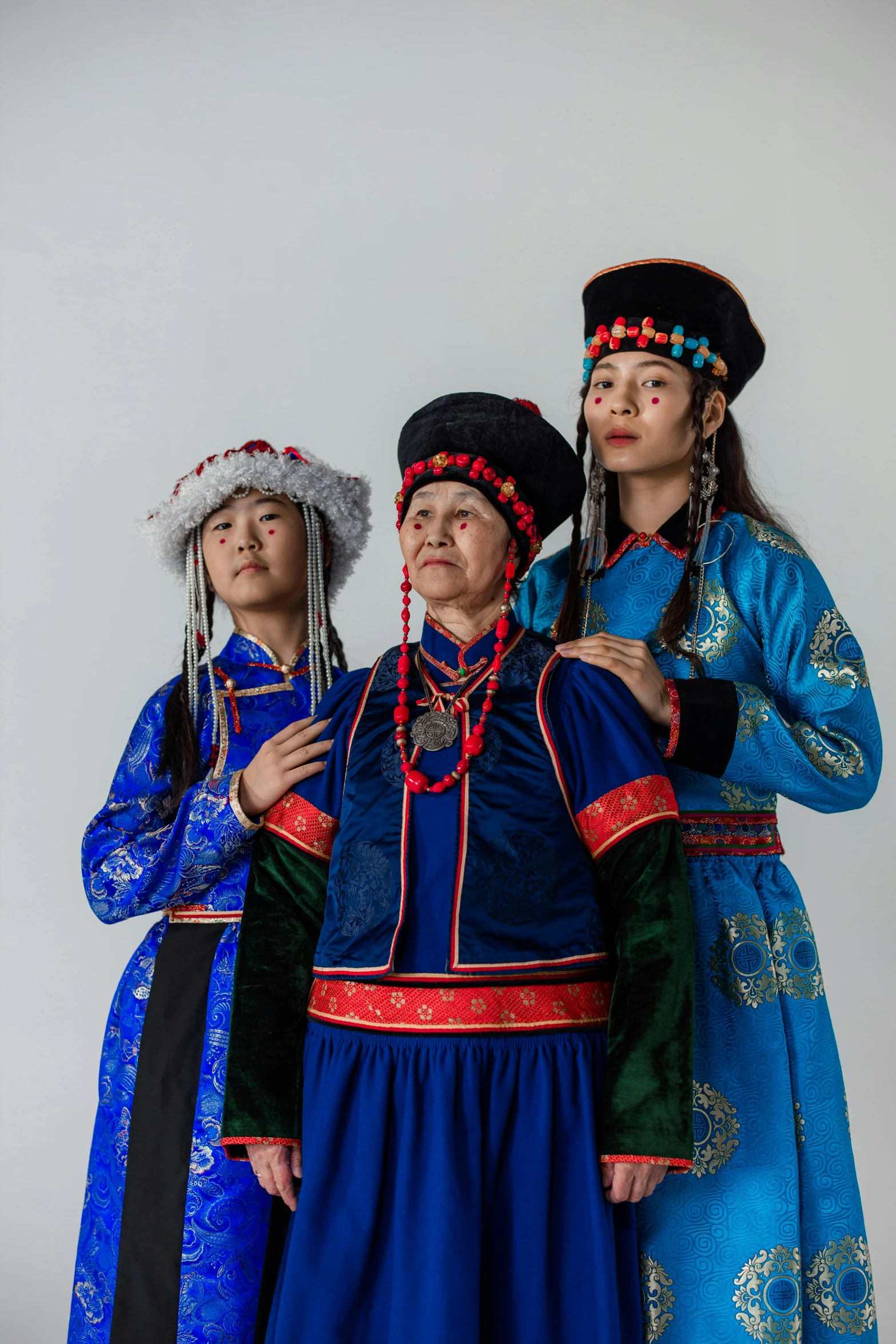 three people with different colored dresses standing together