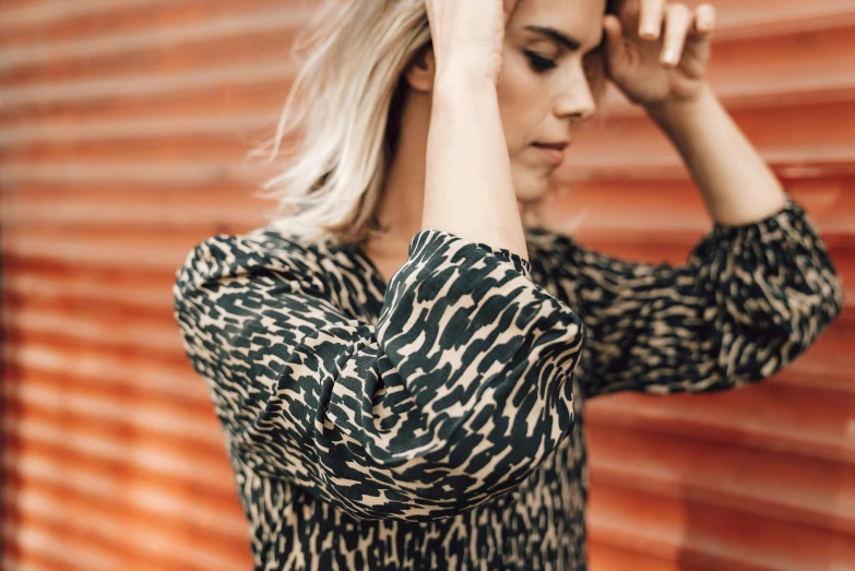 a young blond woman poses in front of a rusty background