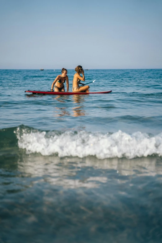 two people on a surf board riding the ocean