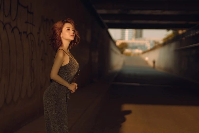 a woman in a silver gown standing in a tunnel