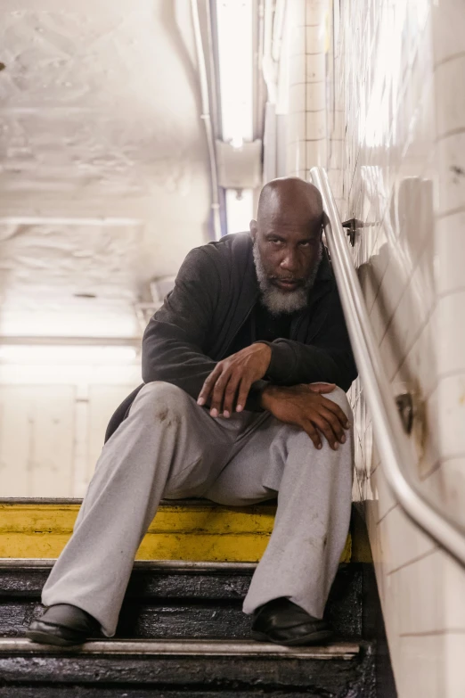 a man with grey hair is sitting on the stairs