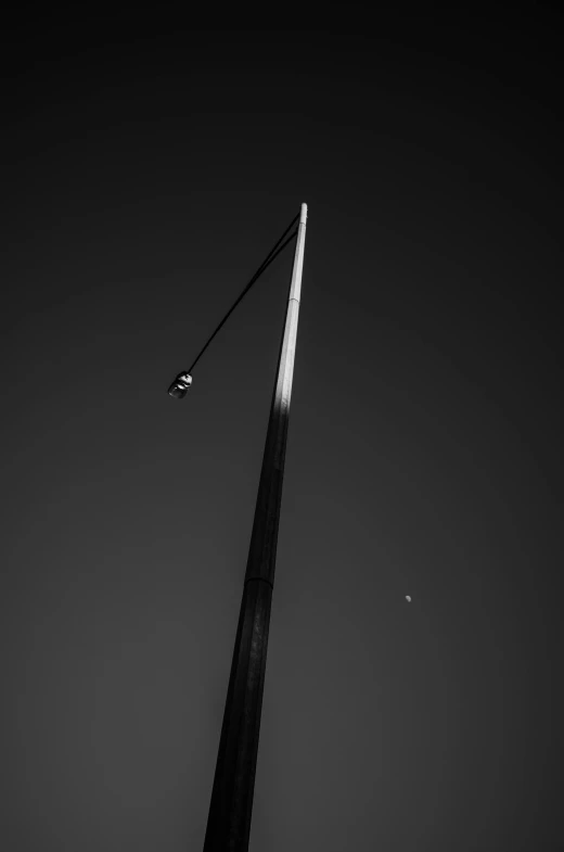 an airplane flying through the sky next to a tall pole
