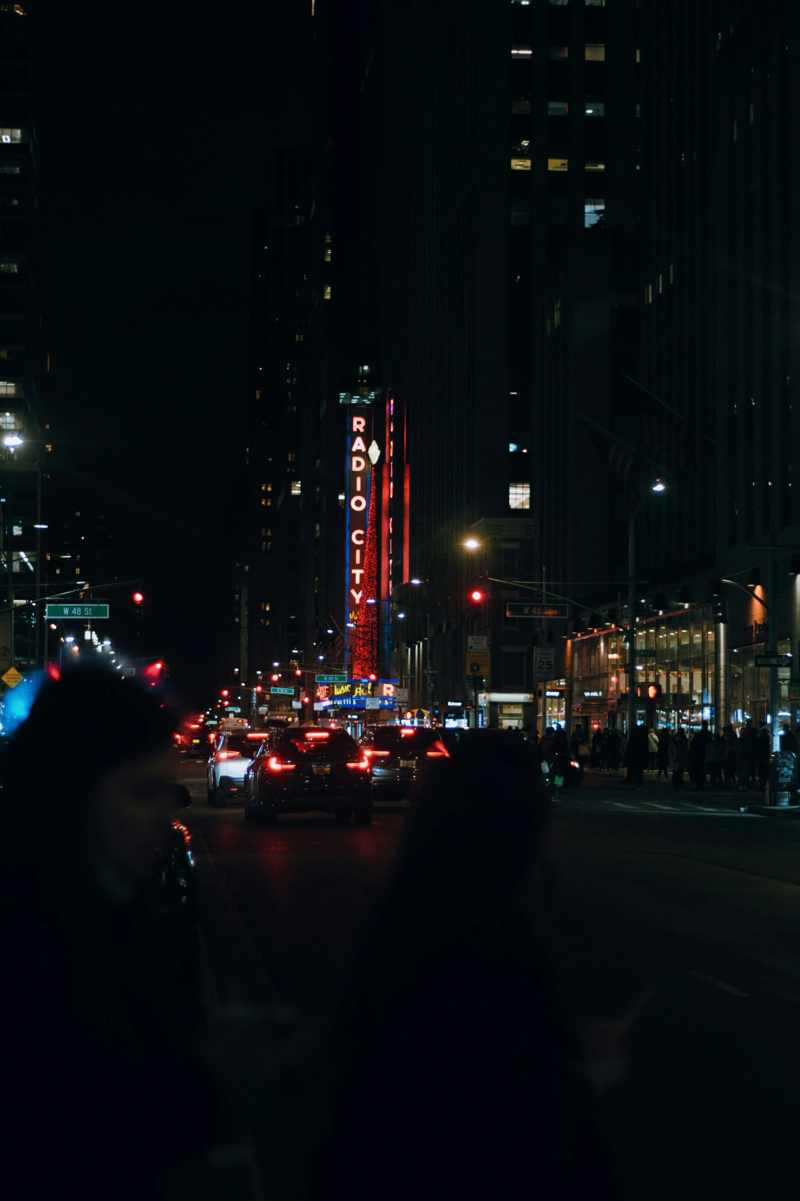 cars parked along side a street in the dark