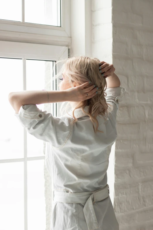 a woman is standing looking out the window