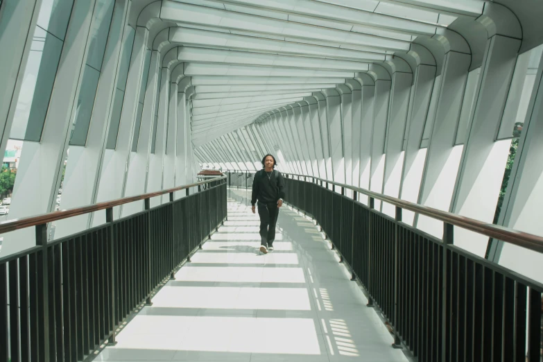 the man is walking down the bridge by himself