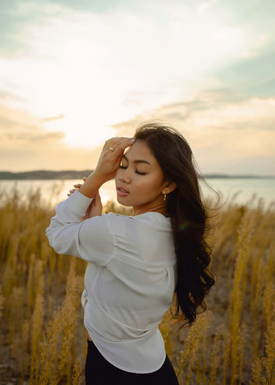 a woman wearing a white blouse is looking into the distance