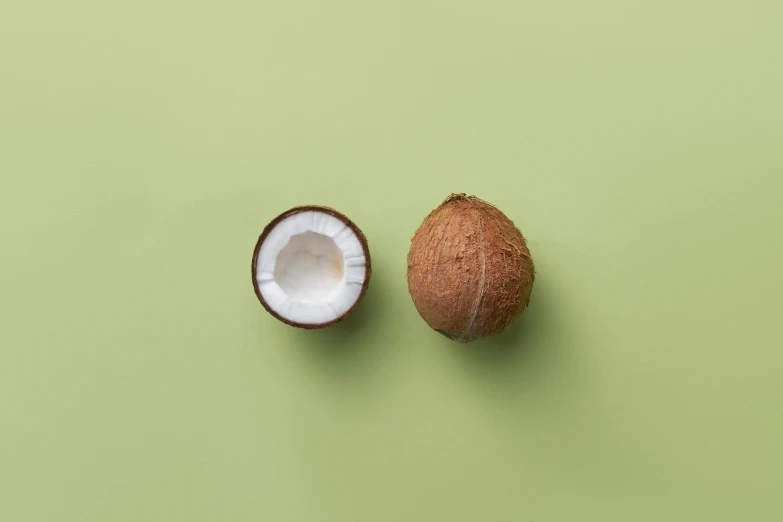 an half - eaten coconut is next to the whole one