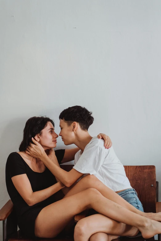 a man sitting next to a woman who is kissing her cheek