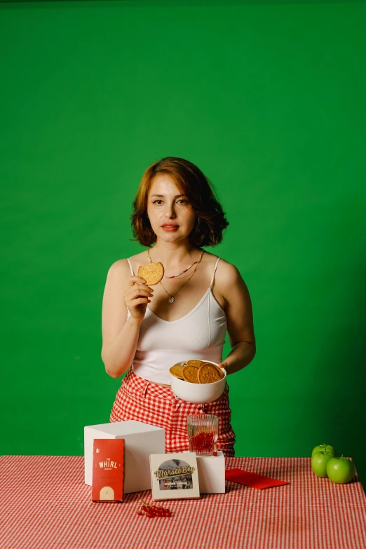 a girl in red checkered shorts posing for a picture with her food