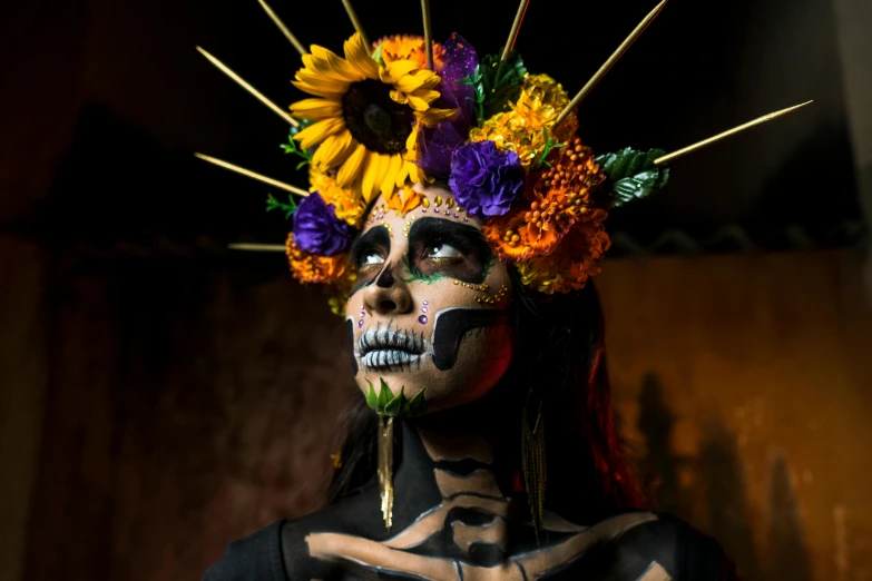 a skeleton make up dressed in black clothing and colorful sunflowers