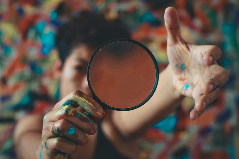 there is a woman making a gesture with her hand and holding a mirror