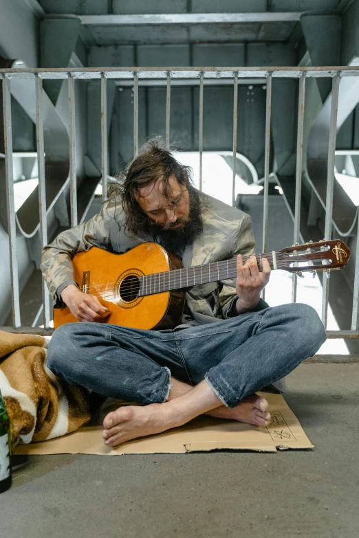 a man that is sitting down with a guitar