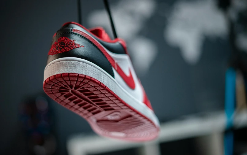 a red and white shoe hanging from a wire