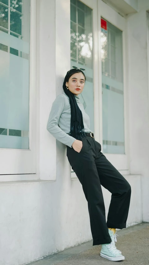 woman standing against a wall leaning on a window