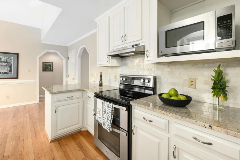 a modern kitchen with a sink, stove and white cabinets