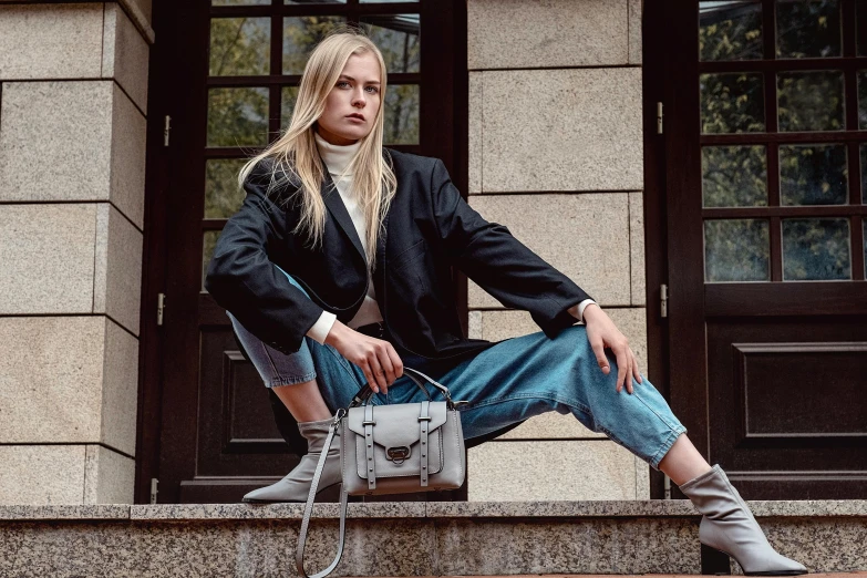 blond haired girl sitting on the stairs holding her purse