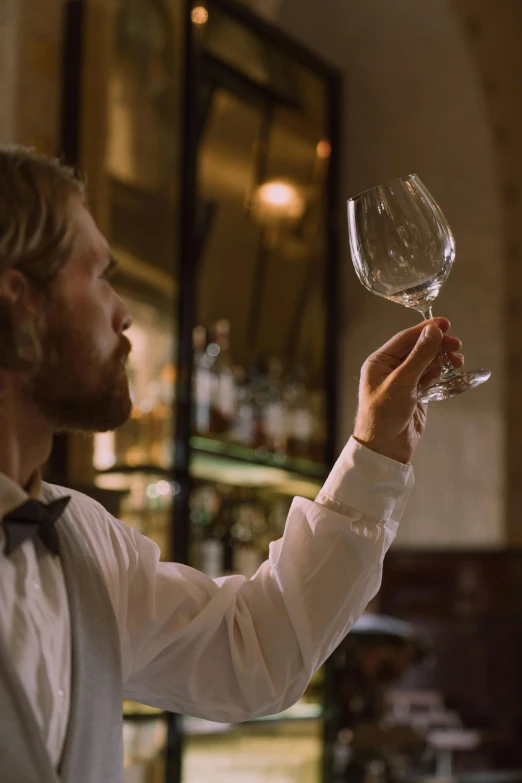 a person holding a wine glass up to his face