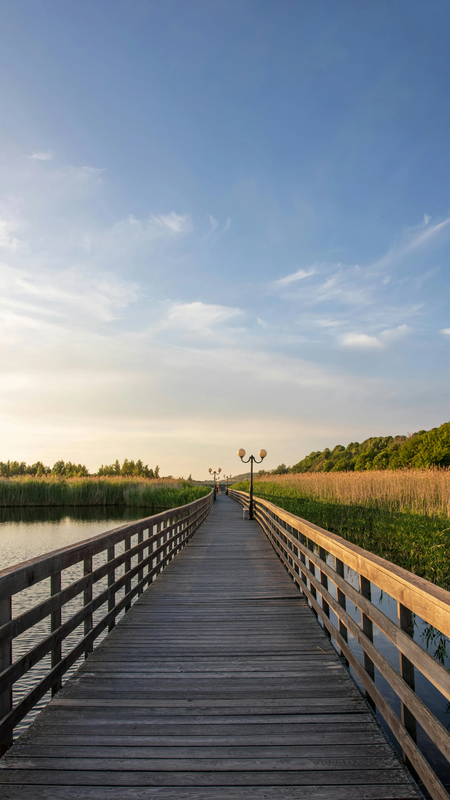 the pier extends into the marsh at sunset