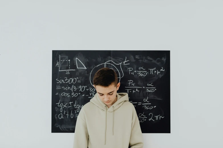 the person stands in front of a wall with math notes on it