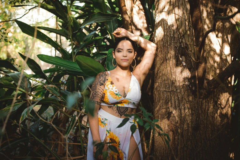 a woman wearing a white bathing suit standing in the forest