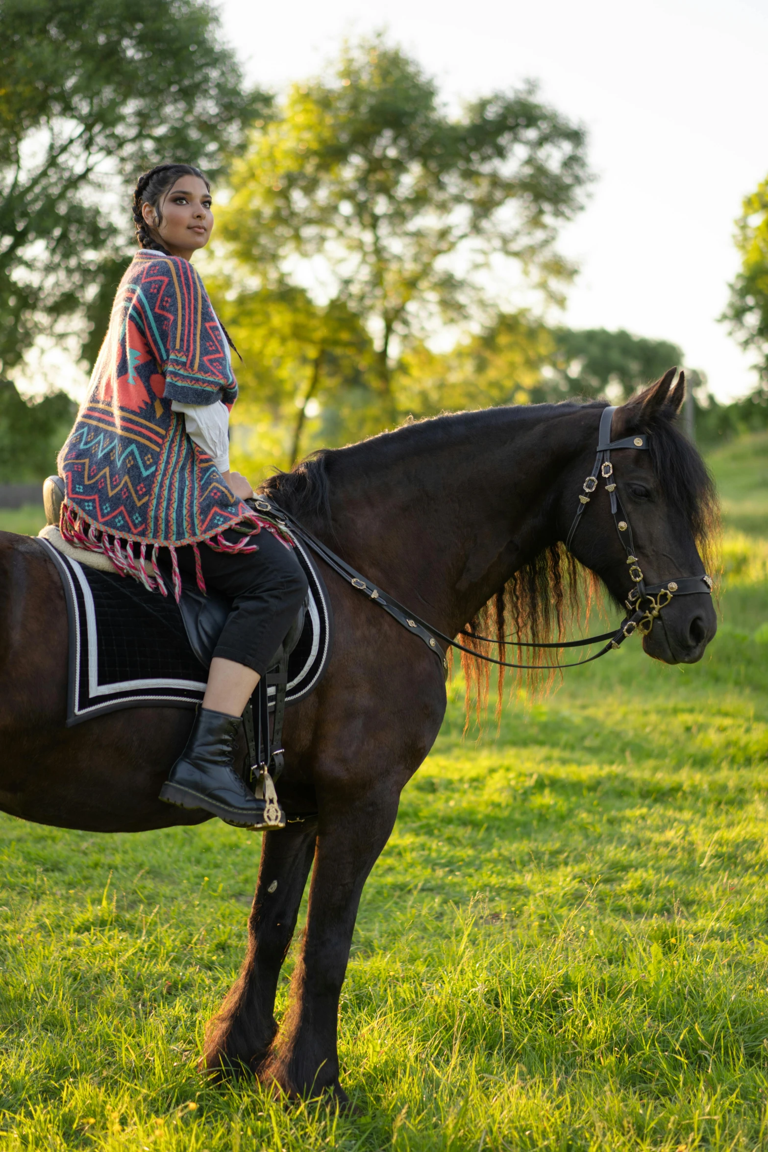 a girl wearing a native american outfit sits on a black horse