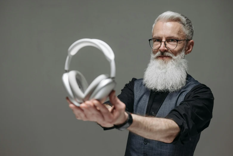 a man with white beard holding some headphones
