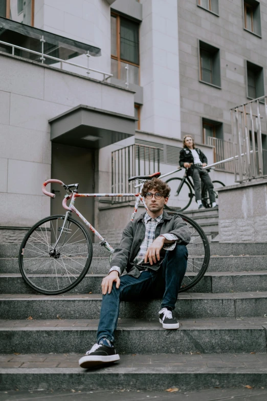 a young man sitting down next to a bike