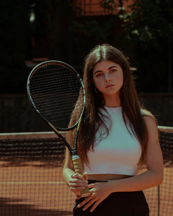 a young woman is holding a tennis racket on a court