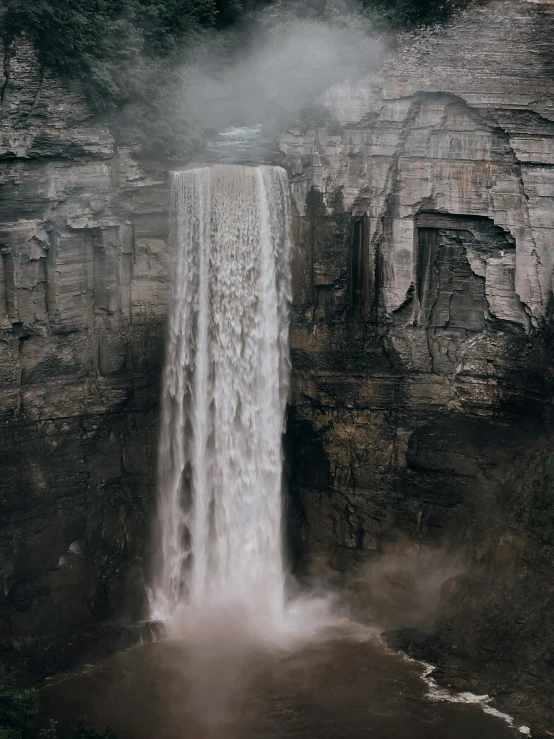 an airplane flies close to a waterfall in the mountains