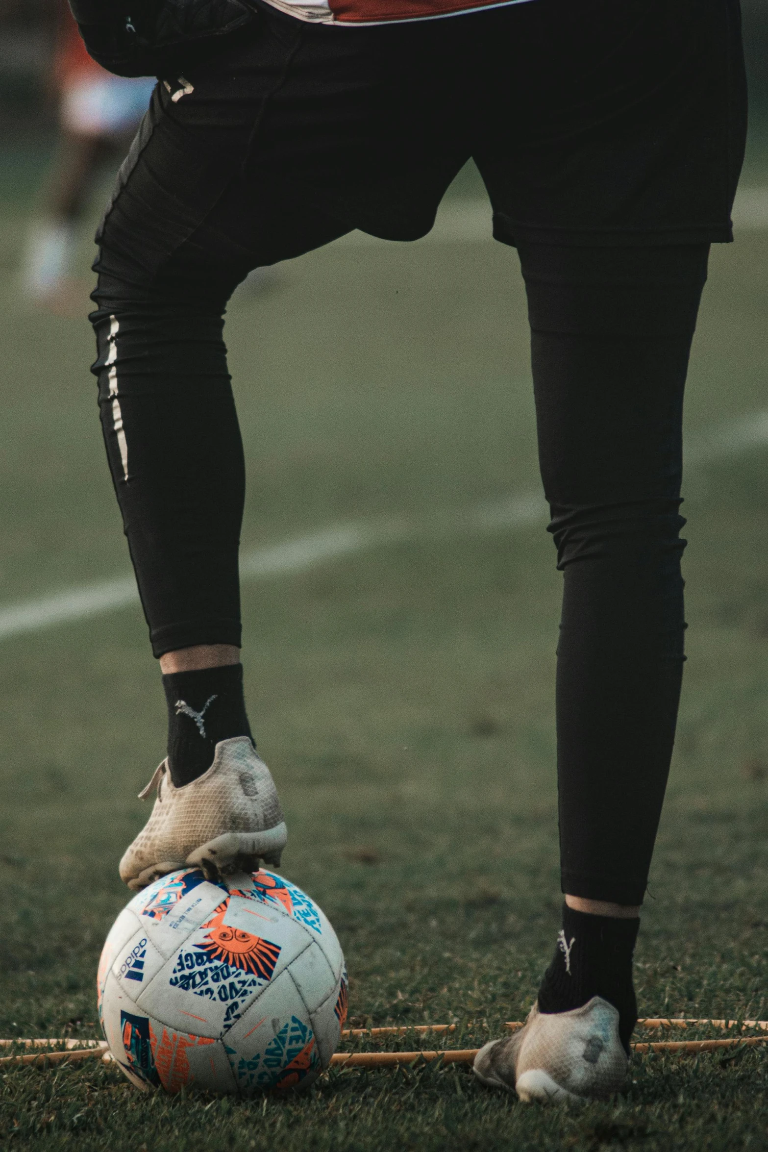 a soccer player balancing on his ball on the field