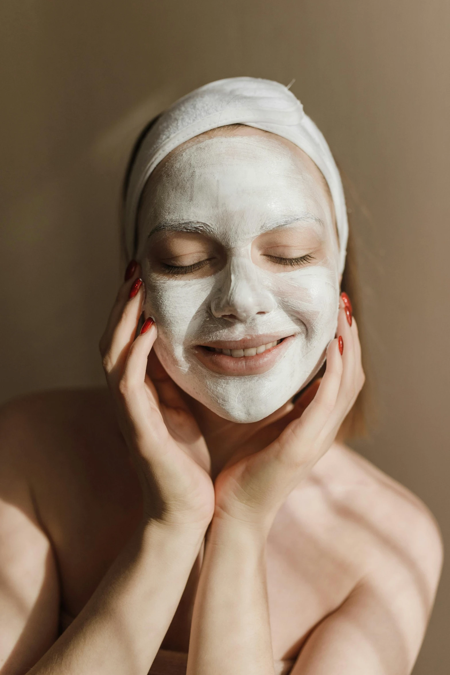 a woman poses for a close up pograph with her face covered in a facial mask