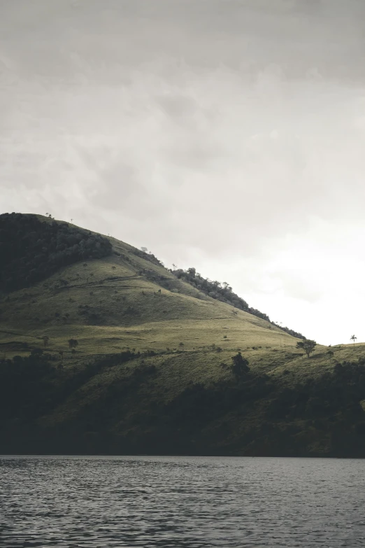 the grass and water is all around the mountain