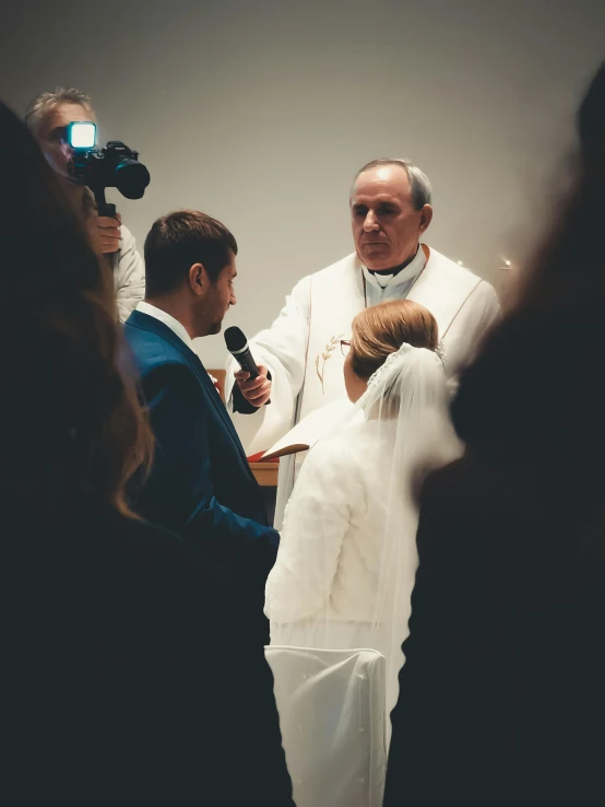 the priest is speaking to his bride and wedding guests