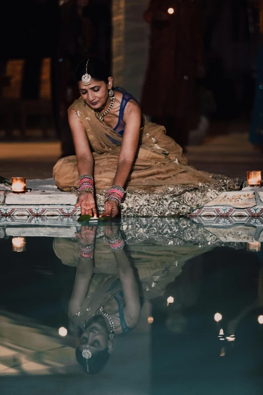 a woman is sitting on the edge of a pool