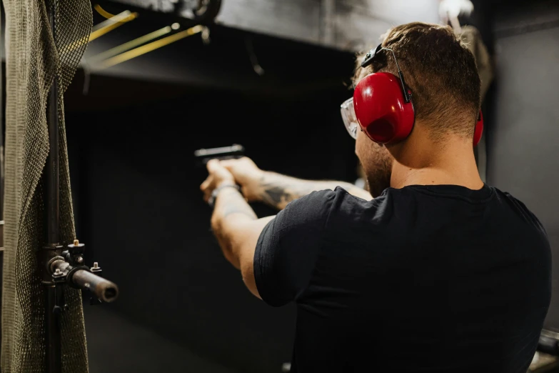 a man with headphones and glasses holding a gun