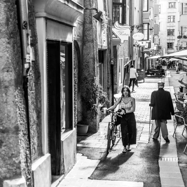 people are walking down the street with bicycles