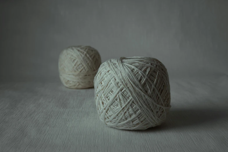 two balls of yarn sit in a studio po