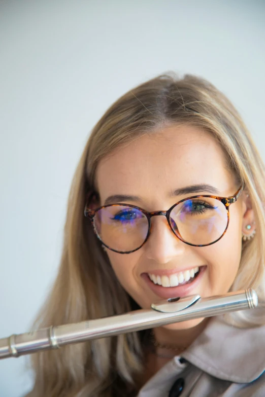 a woman with glasses holding a large white tooth brush