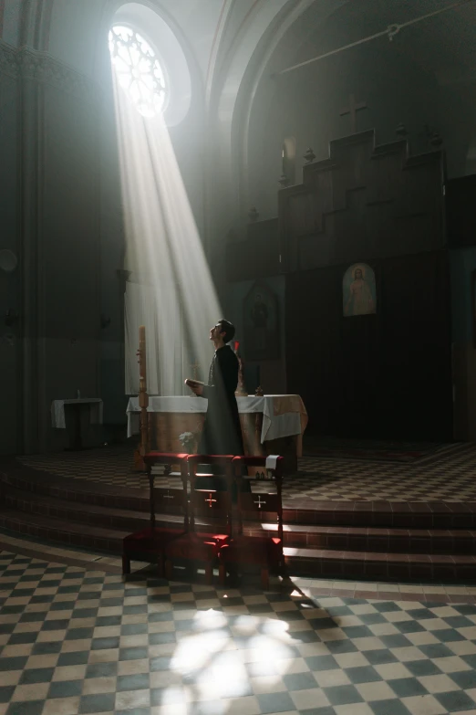 the priest in white robe is standing at a alter in the church