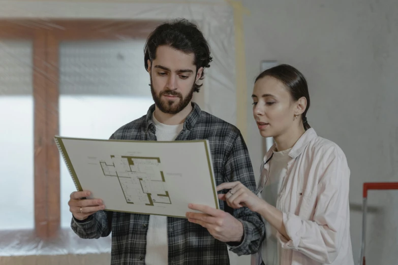 a man holding a sheet of paper looking at it