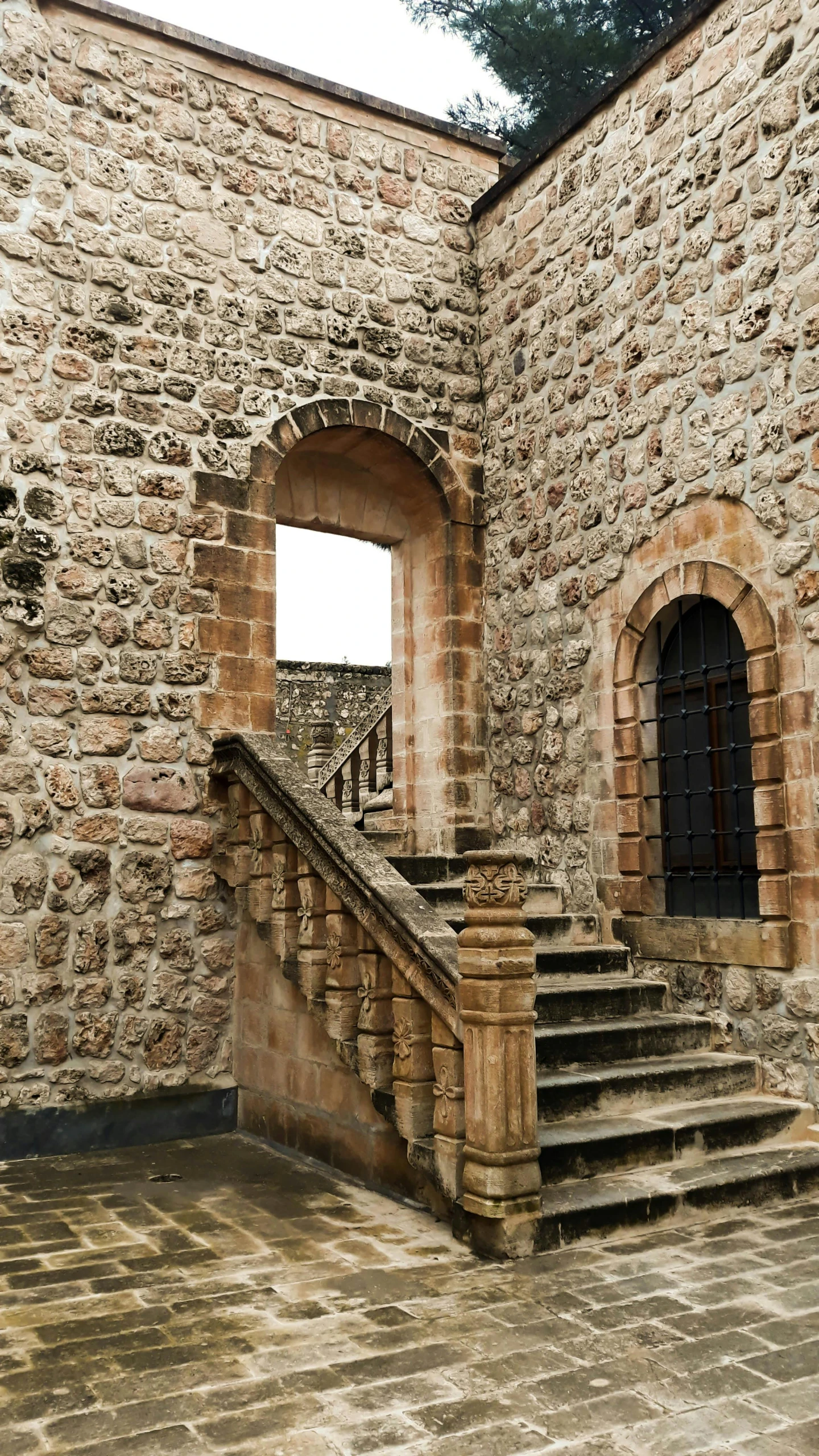 a stone building with steps and arched windows