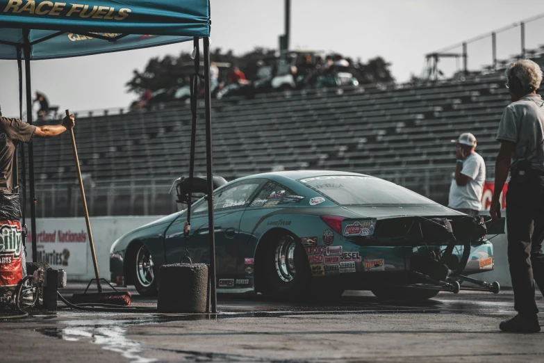 an older man standing next to a race car