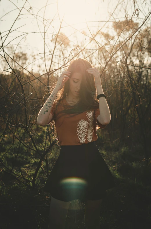 a girl with her head down is holding her hair