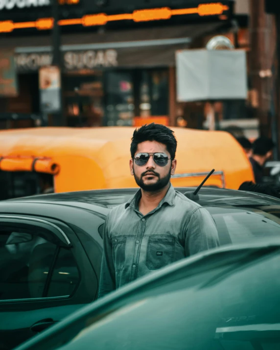 a man in green shirt standing by car